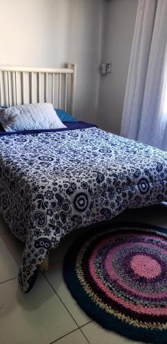 大坎普Casa verde的一张带蓝色和白色毯子和地毯的床