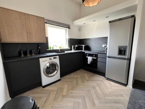 Luxury home in rugby ready 4U的厨房配有洗衣机和洗衣机。