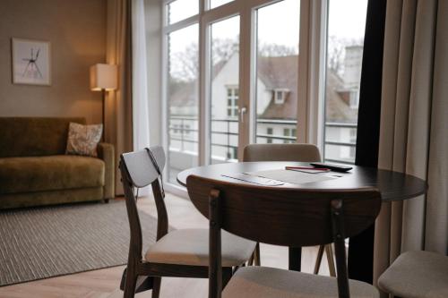 斯海弗宁恩By Friso Den Haag的客房设有桌椅和大窗户。