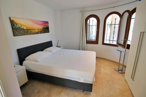 卡隆赫Villa Ensueño的卧室配有白色的床和2扇窗户。