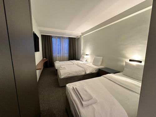 普列夫利亚Hotel Pljevlja的酒店客房设有两张床和窗户。