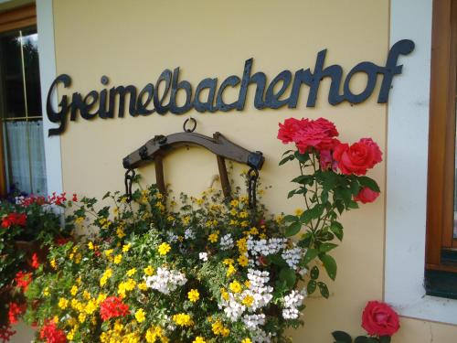 拉姆绍达赫斯坦Pension-Greimelbacherhof的花房边的标志