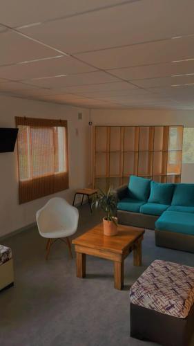 马德普拉塔Alfar Hostel的客厅配有蓝色的沙发和桌子