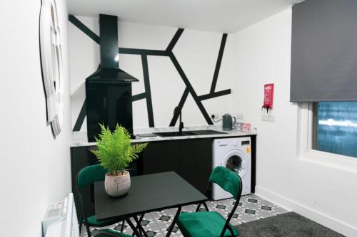 布赖尔利希尔Ledger Loft的洗衣房配有桌子和绿色椅子