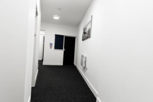 布赖尔利希尔Gold Reserve Retreat的走廊上设有白色墙壁和黑色地毯