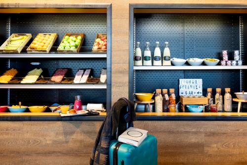 戴斯阿伯丁机场慕奇夕酒店的放在食物架前的长凳上的手提箱