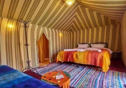 梅尔祖卡Desert Berber Fire-Camp的一间设有两张床和一张桌子的房间
