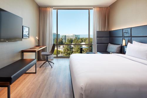 圣克拉拉AC Hotel by Marriott San Jose Santa Clara的配有一张床、一张书桌和一扇窗户的酒店客房