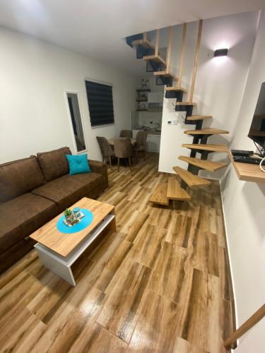 Crni VrhBlue Lagoon Apartments的带沙发和楼梯的客厅