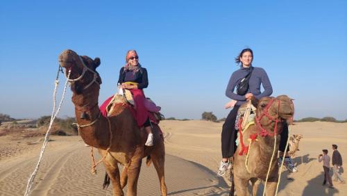 斋沙默尔Hostel Desert Home Stay的两个骑骆驼的人