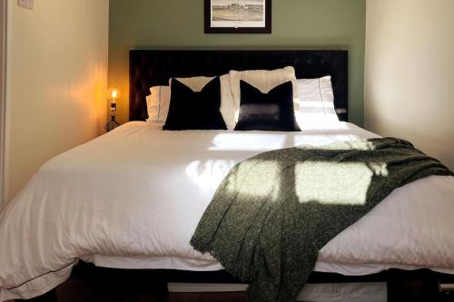 伦敦Chic, Relaxing stay just 18 mins into the City的卧室配有一张带黑色枕头的大型白色床。