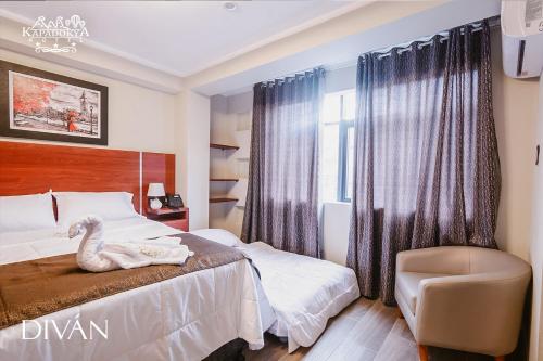 瓦努科Hotel Kapadokya的卧室配有天鹅床和椅子