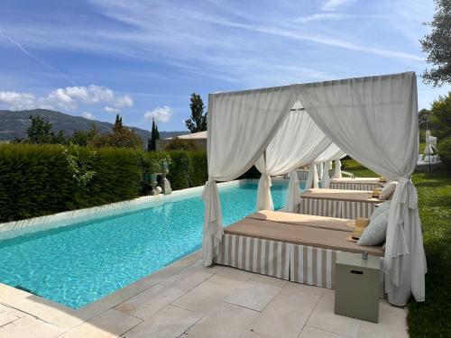 蓬德利马嘉模精品酒店 - 世界小型豪华酒店的游泳池畔的一张带天蓬的床