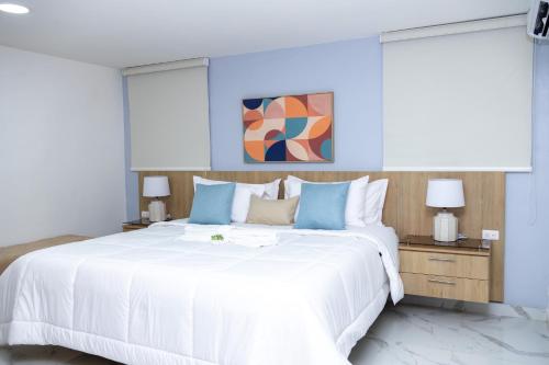 HigueyHabana Hotel Y Restaurante的卧室配有一张蓝色色调的大型白色床。