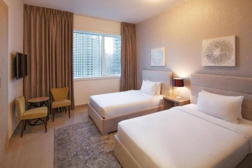 迪拜Marina Two Bedroom With Balcony - KV Hotels的酒店客房设有两张床和窗户。