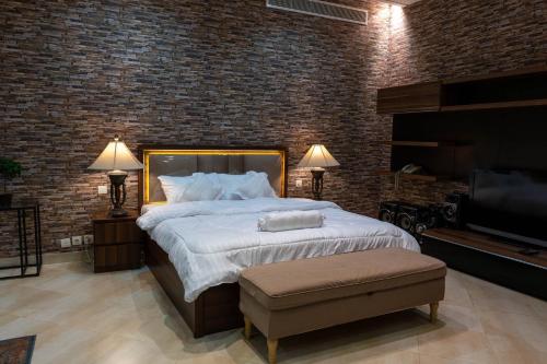 麦地那فيلا كامله للايجار اليومي的一间卧室设有一张大床和砖墙