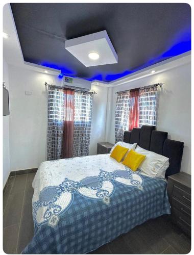 La CaletaJC Caribe Aparta Hotel #1的一间卧室配有一张蓝色灯床