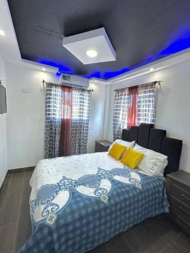 La CaletaJC Caribe Aparta Hotel #1的一间卧室配有一张蓝色灯床