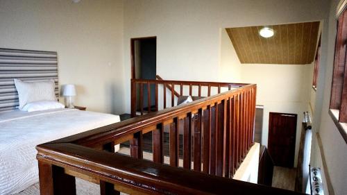 阿克拉Cliffhaven Beach Resort Hotel的一间卧室设有一张床和木制楼梯栏杆