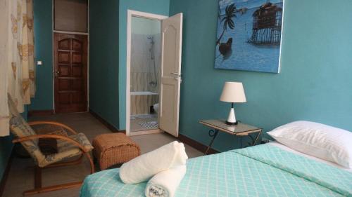 阿克拉Cliffhaven Beach Resort Hotel的卧室拥有蓝色的墙壁,配有一张床和椅子