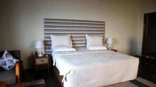 阿克拉Cliffhaven Beach Resort Hotel的卧室配有一张带白色床单和枕头的大床。