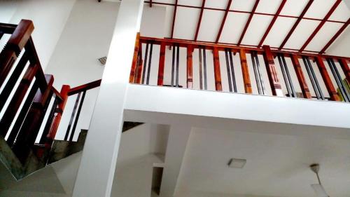 Gonapinuwala WestVero villa的房屋内有红色栏杆的白色楼梯