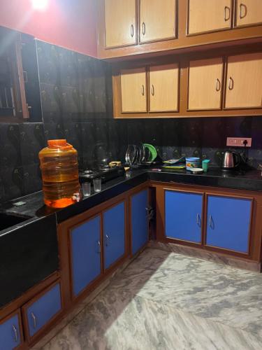 蒂鲁帕蒂SM Homestays 2的厨房配有黑色台面和蓝色橱柜