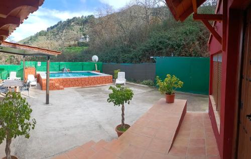 贝加德圣马特奥Chalet Ruta Las Lagunetas的庭院设有游泳池、树木和围栏