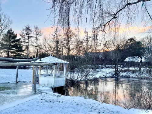 KarrebæksmindeCozy Rooms at Organic Vinery, Vesterhave Vingaard - see more at BY-BJERG COM的河边的雪地凉亭