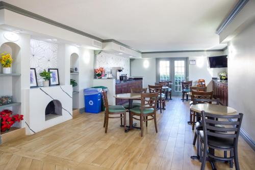 奥斯汀Baymont by Wyndham Austin University Area的一间带桌椅的用餐室和一间厨房