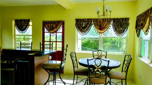 Grays HillZeus Guesthouse的一间带桌椅和窗户的用餐室