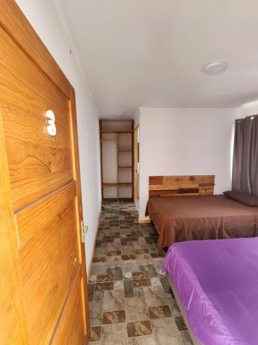 伊基克El Pescador的一间设有两张床和一扇门的房间