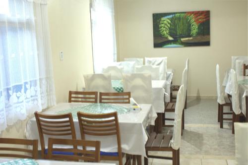 卡皮托利乌Hotel Minastur的一间配备有白色桌椅的用餐室