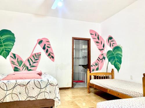 弗洛里亚诺波利斯Floripa Camping e Hostel的卧室配有两张床,墙上有棕榈叶