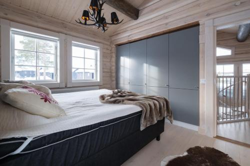 萨伦Exklusiv ski in-ski out stuga, i Hundfjället Sälen的一间带一张大床的卧室,位于带木墙的房间