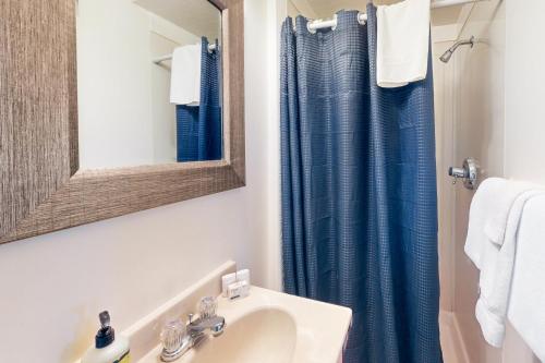 欧申赛德Wave Watch `N的浴室设有水槽和蓝色的浴帘