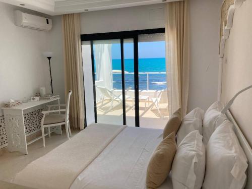 拉马萨Dar Corniche La Marsa (Adults Only)的一间卧室设有一张床,享有海景