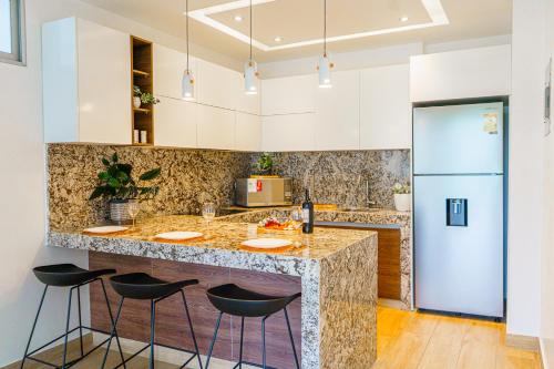 瓜亚基尔Luxury Apartments estilo New York的厨房配有大理石台面和凳子