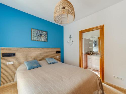 哈维亚Casa de la Buena Vida的一间卧室设有一张床和蓝色的墙壁