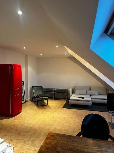 杜塞尔多夫OBK City Lodge: Designer duplex appartment in Oberkassel, close to river rhine, Areal Böhler and Messe Düsseldorf的带沙发和红色冰箱的客厅
