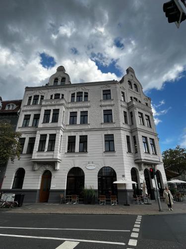 杜塞尔多夫OBK City Lodge: Designer duplex appartment in Oberkassel, close to river rhine, Areal Böhler and Messe Düsseldorf的街道拐角处的白色建筑