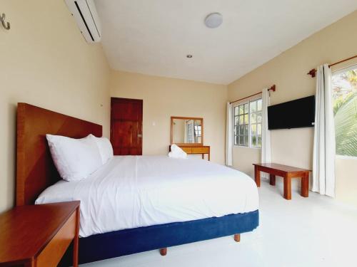 Dzilam de BravoCasa Azul Cielo的卧室设有一张白色大床和一扇窗户。