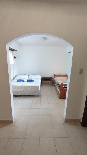 内科切阿Departamento en Necochea的客房设有两张床,铺有瓷砖地板。