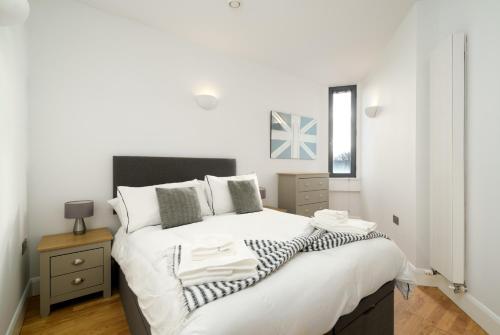 伦敦Luxury Central London Penthouse的卧室配有一张带白色床单和枕头的大床。