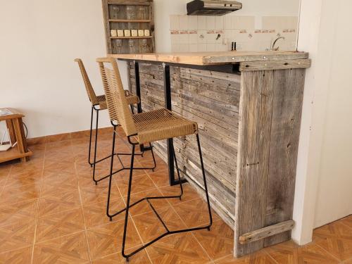 佩里托莫雷诺Hostel Tierra Patagónica的厨房配有带2把椅子的木台