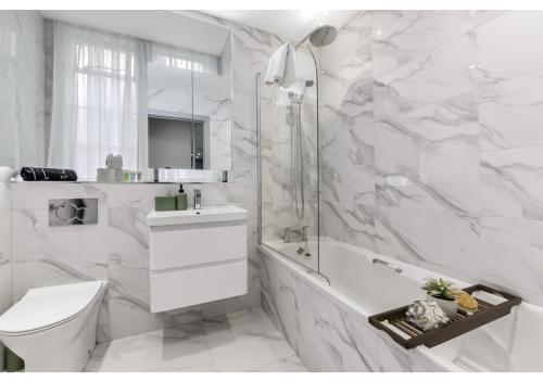 伦敦Modern Comforts 2 BD Flat - Sleeps 5的白色的浴室设有卫生间和淋浴。
