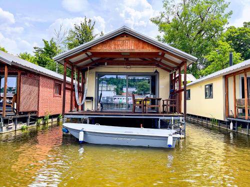 布拉格Houseboat Franklin - Houseboats Benjamin & Franklin的建筑物旁边的水面上有船的房子