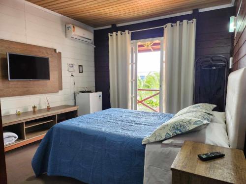 佩尼亚Beto Pousada的一间卧室配有蓝色的床和电视