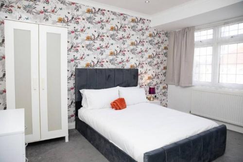 GoodmayesA hidden Gem in the heart of Dagenham!的卧室配有白色床和花卉壁纸