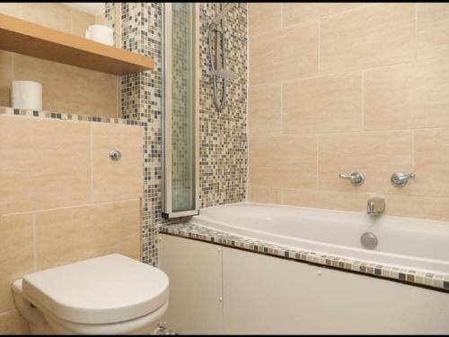 GoodmayesA hidden Gem in the heart of Dagenham!的浴室配有卫生间、浴缸和水槽。